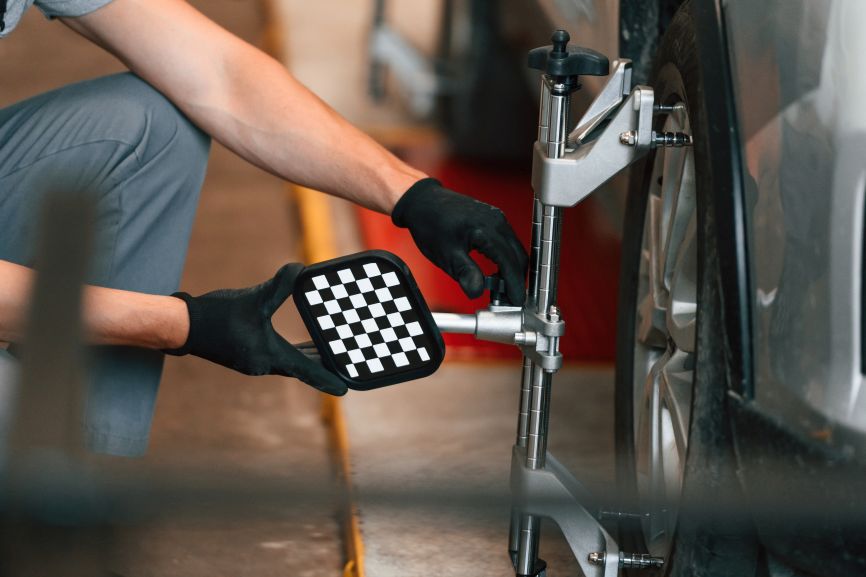 : An Auto King technician attaches precision alignment equipment to a vehicle wheel, demonstrating how professional geometry checks can identify incorrect wheel angles before they cause pulling, off-centre steering or premature tyre wear